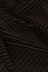 Digital fabric cutting of shiny cupro lining fabric in black background with white ticking pin stripe and orange skinny stripe, twice the width of white. Fabric has folds as if dropped on ground and fills entire frame.