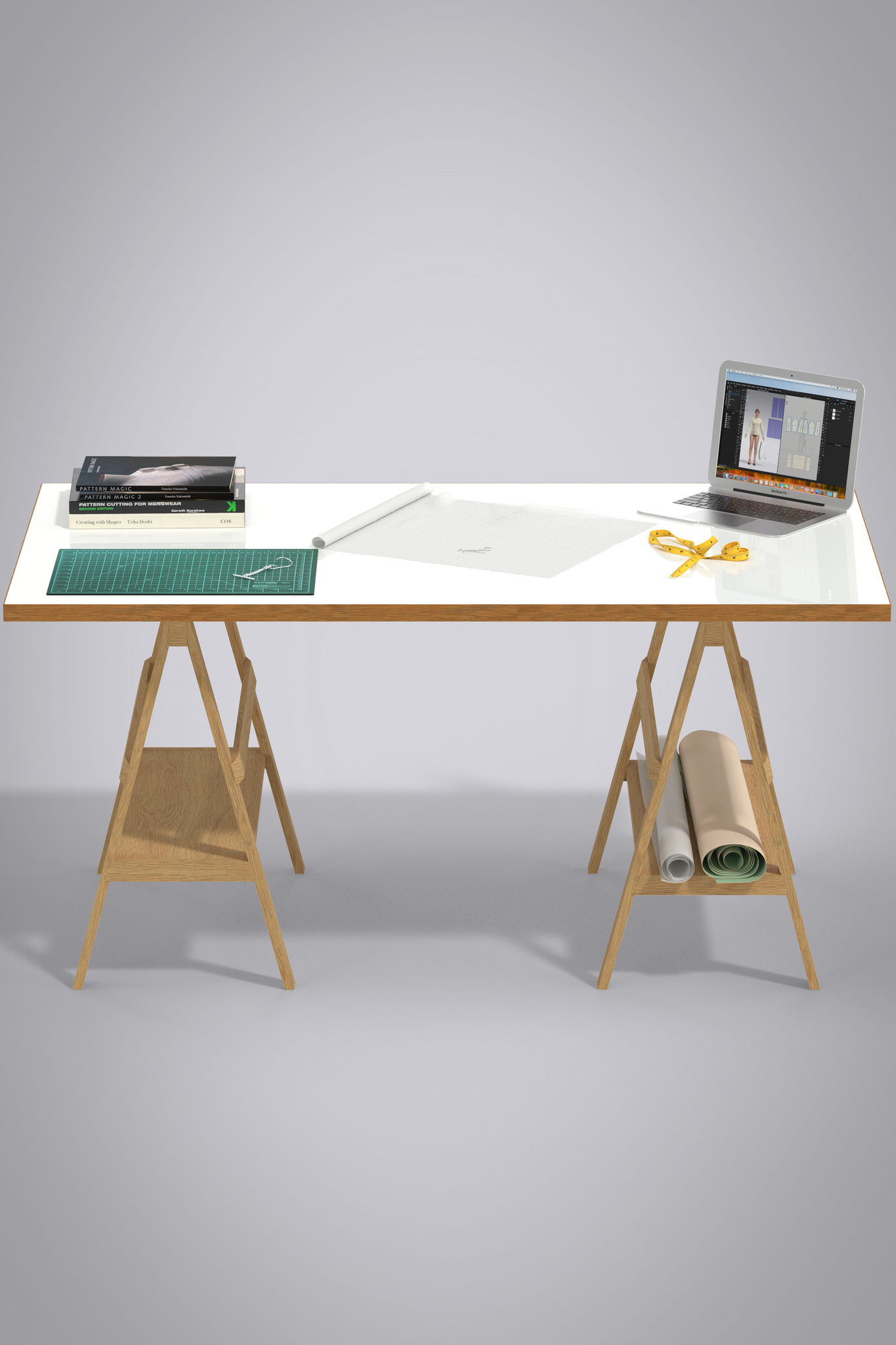 Design Desk scene of 3D objects. Desk is white with wood side on wooden saw horse legs. Roll of pattern paper and oaktag cardstock paper on shelf of right leg. On desk is apple laptop, yellow tape measure, piece of pattern paper unrolling, cutting mat with pattern hook lying on it, stack of 3 pattern making books. 