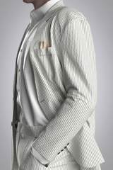 Male avatar wearing 3D digital suit in seersucker striped fabric of grey/green and white stripes. Image shown from left side of body from hip to chin with left hand in pant pocket.