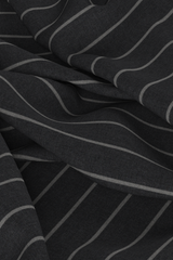 Digital fabric, dark grey worsted wool suiting with double-wide white pinstripe. Fabric is draped on ground with loose folds, fills entire frame.