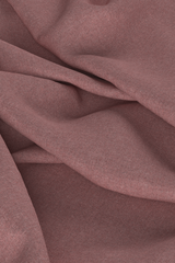 Digital fabric, pink worsted wool suiting. Fabric is draped on ground with loose folds, fills entire frame.